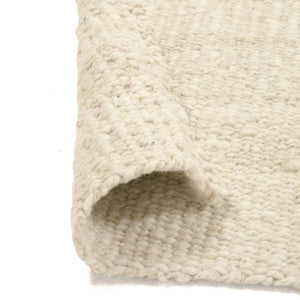 Close-up of a textured beige rug corner on a white background - Number 3