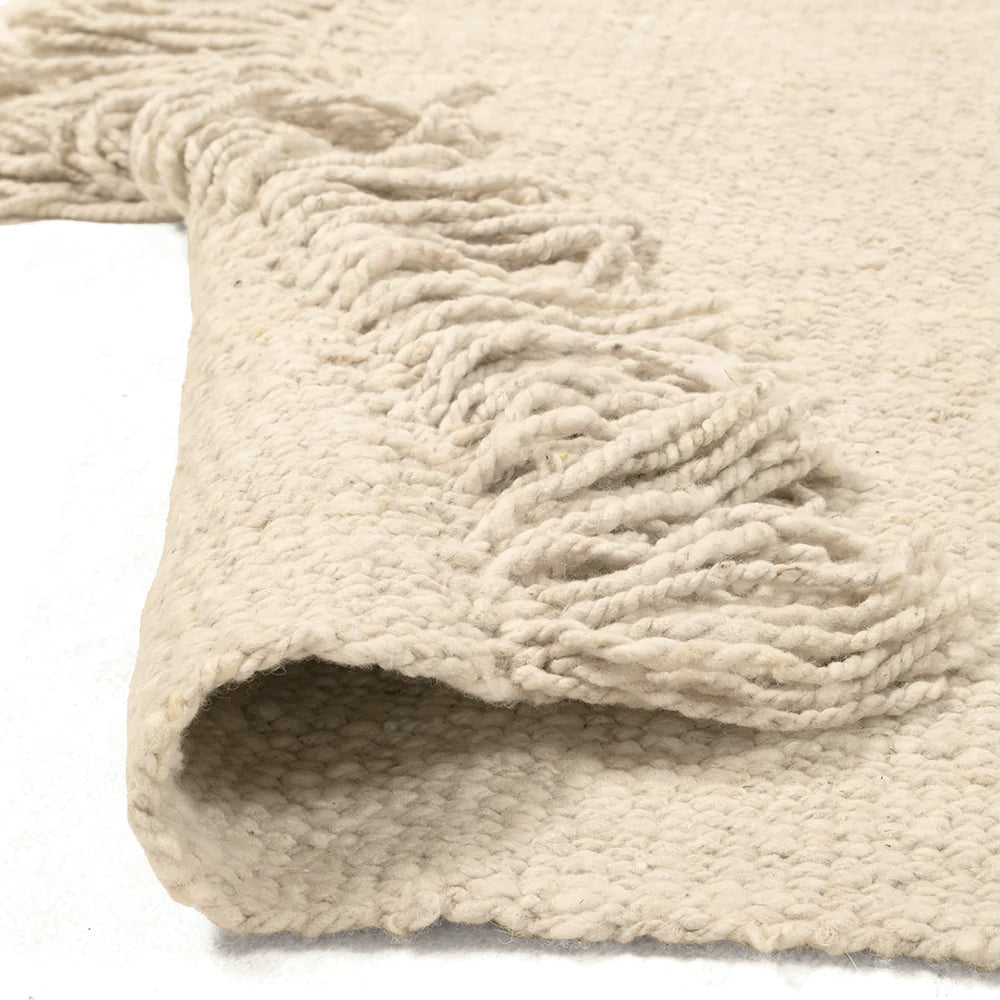 Close-up of a textured beige rug with fringe on a white background- Number 3