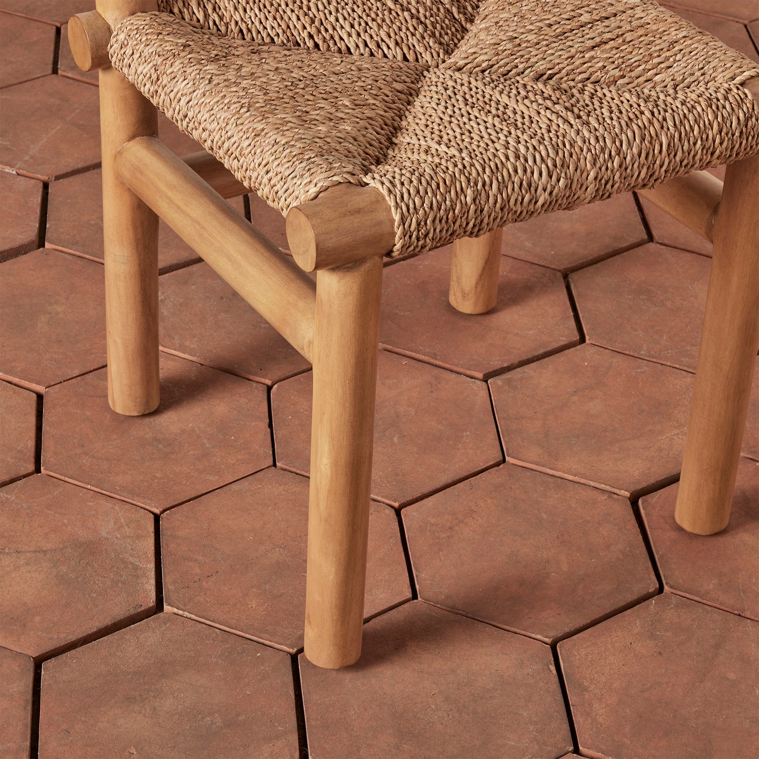 Wooden chair with woven seat on a hexagonal tile patio- Number 8
