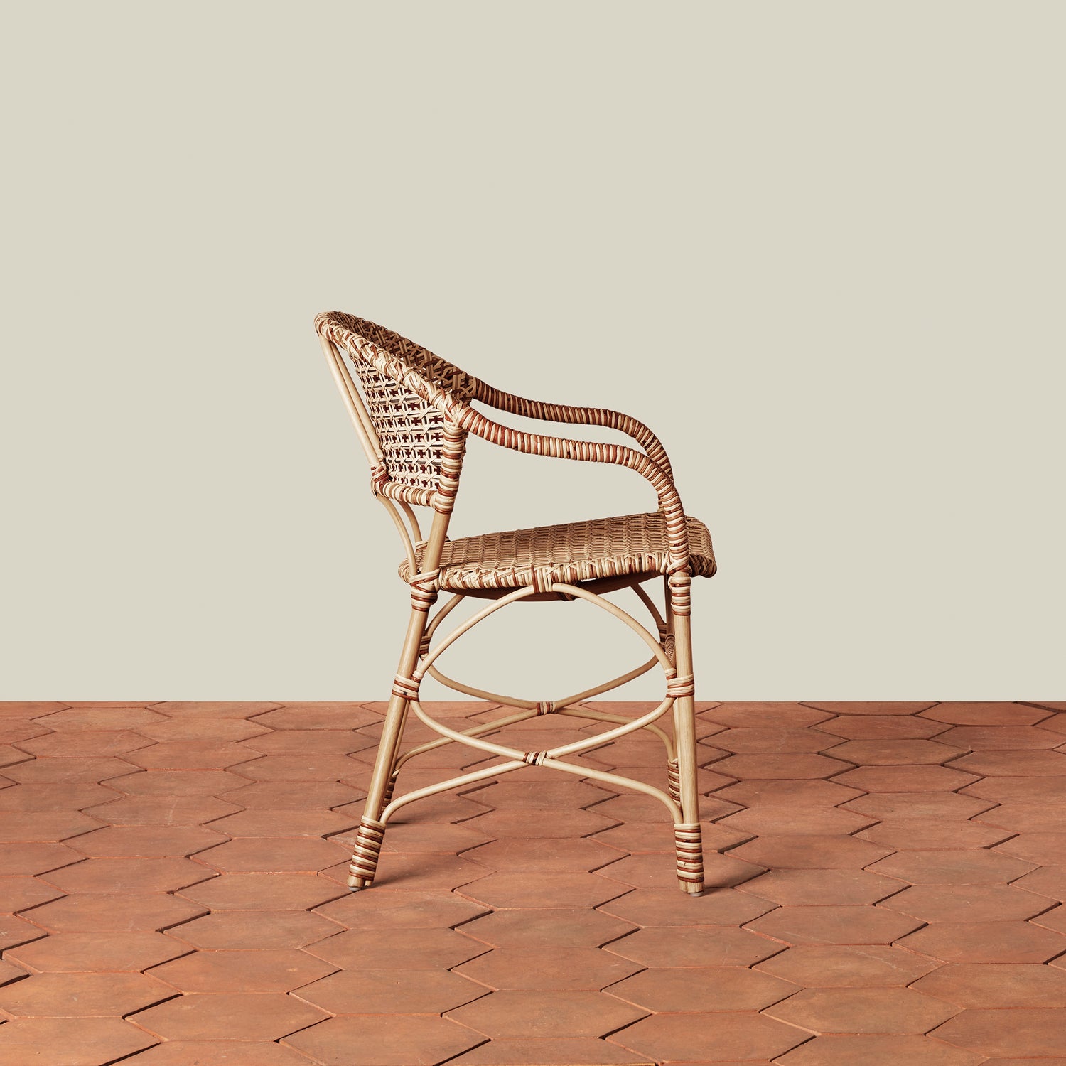 beige woven chair on tile floor with neutral background- Number 6