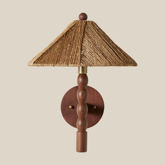 wood sconce with rattan shade hanging on wall