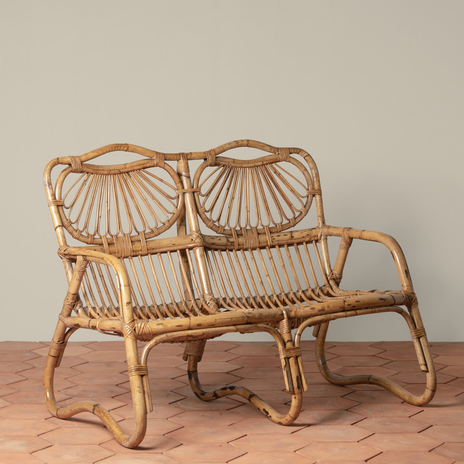 vintage rattan loveseat on tiled floor- Number 1