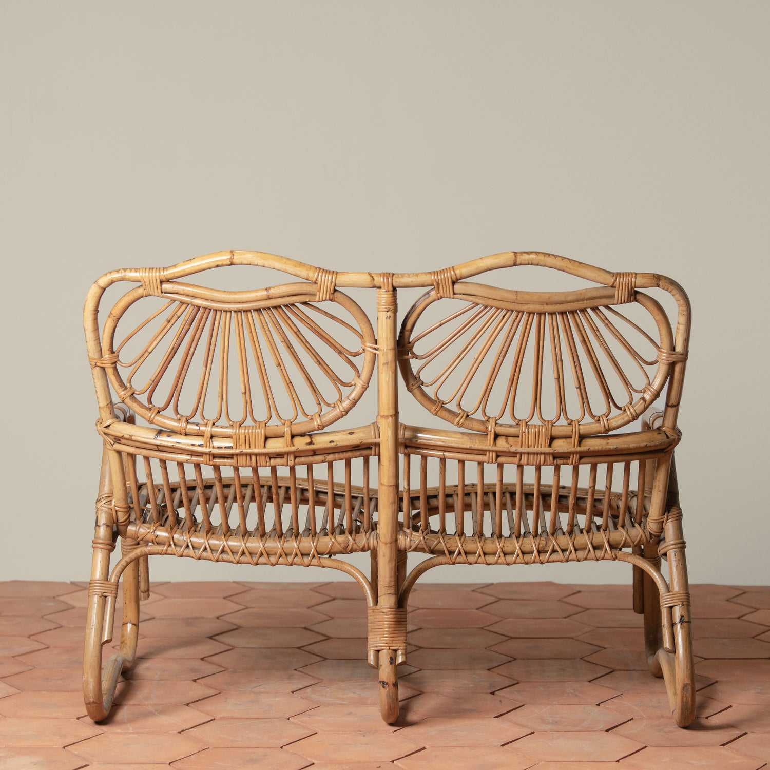 back of vintage rattan loveseat on tiles floor- Number 5
