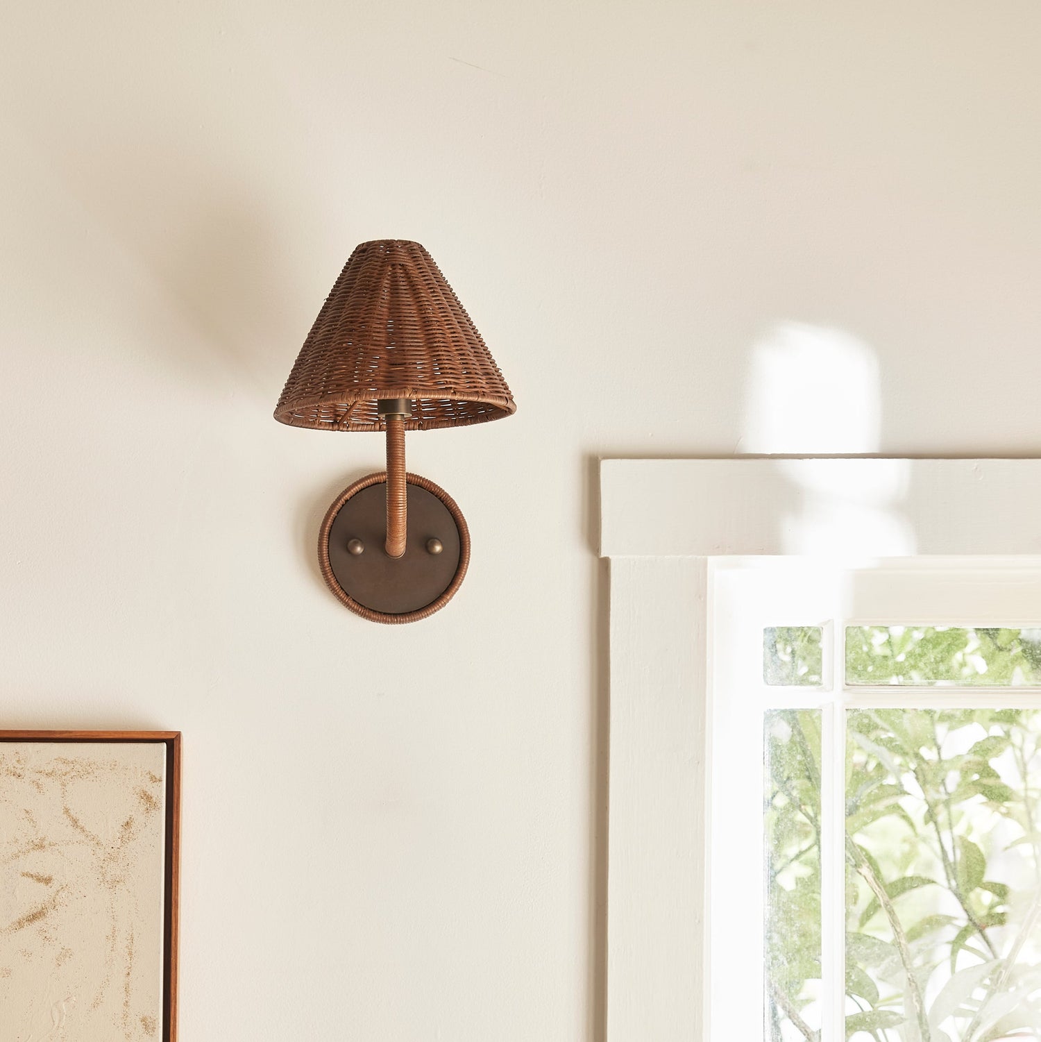 Woven wall sconce on a neutral wall with decor items below- Number 2