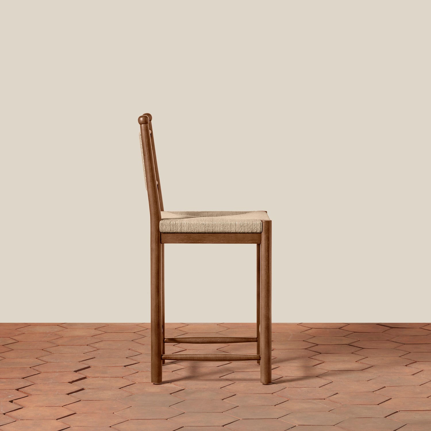Wooden bar stool with woven seat on a wooden floor and beige wall background- Number 3