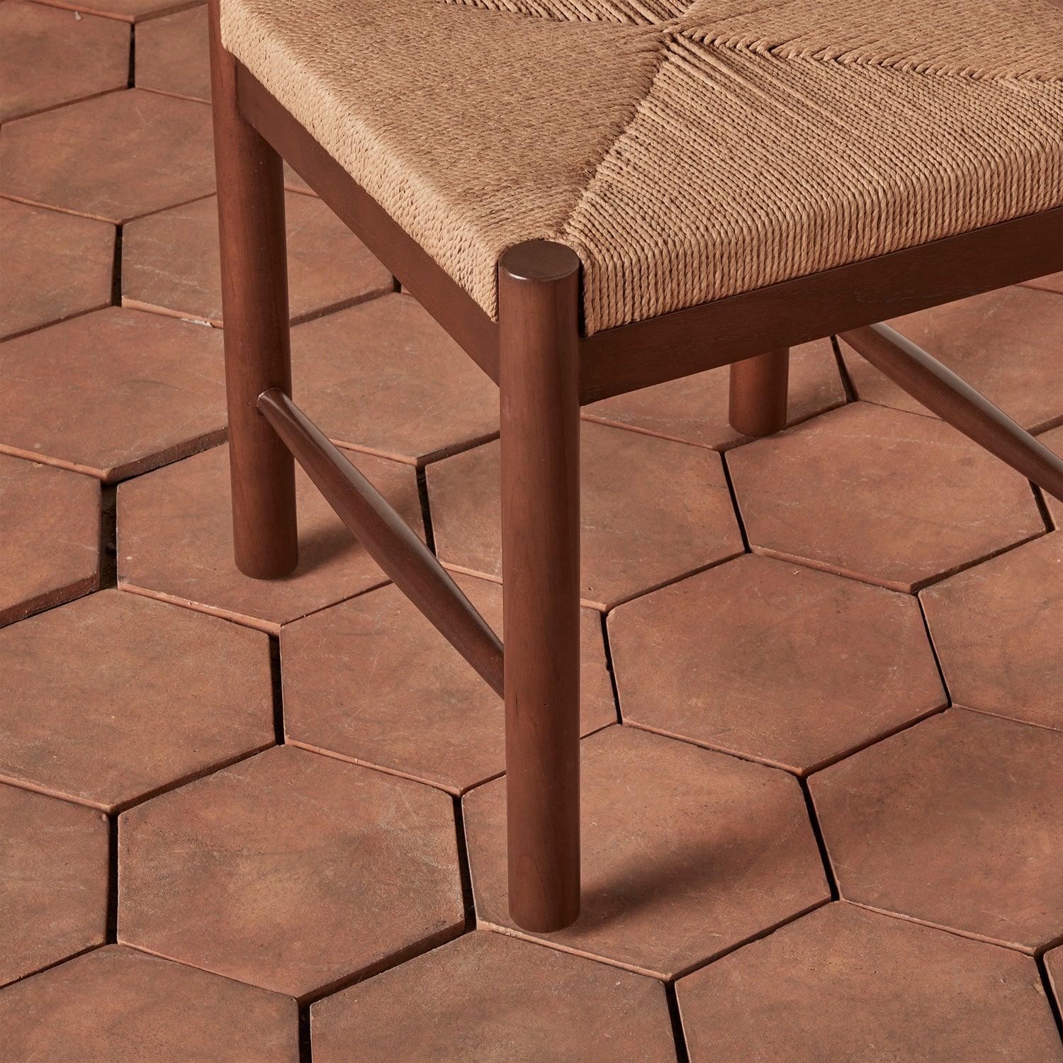 Chair with woven seat on a hexagonal patterned patio floor- Number 8