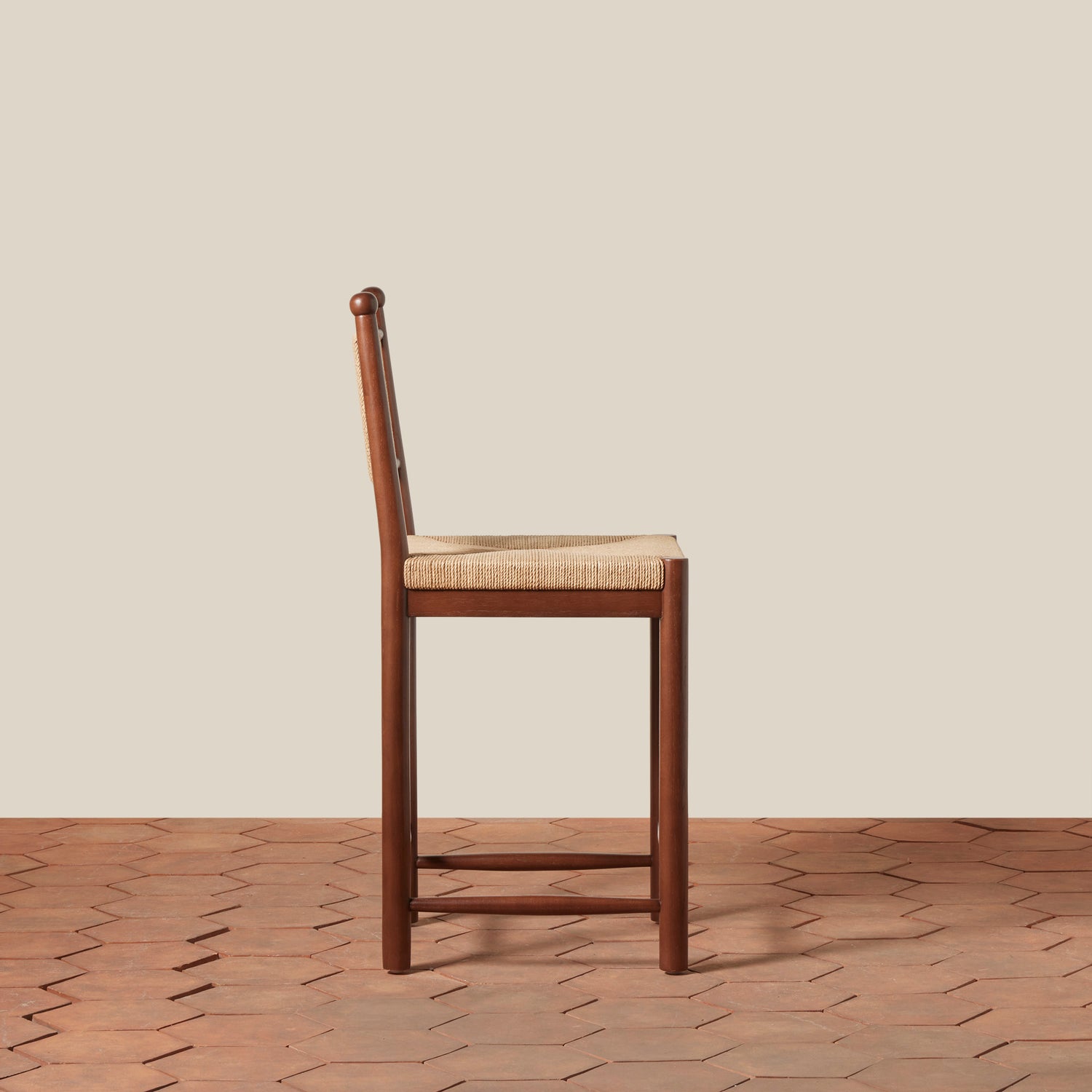 Wooden bar stool with woven seat on a wooden floor and beige wall background- Number 2