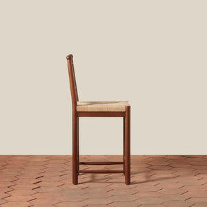 Wooden bar stool with woven seat on a wooden floor and beige wall background - Number 2