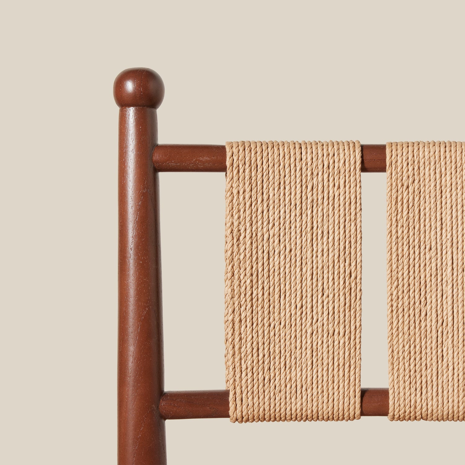 Wooden chair with a beige woven backrest against a beige wall- Number 5