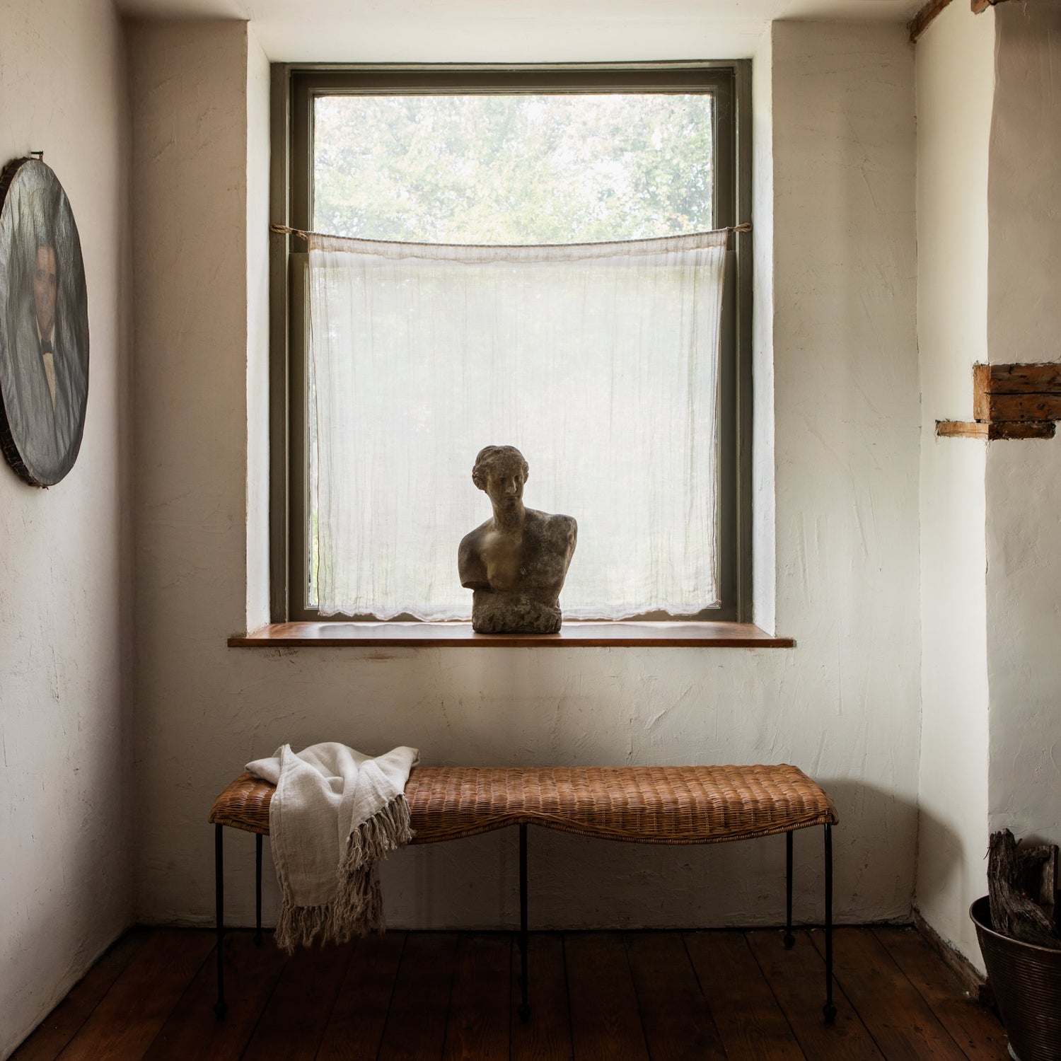 Room interior with a bench, window, and sculpture.- Number 3
