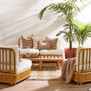 Outdoor seating area with wicker chairs, a sofa, and a coffee table with decorative items. - Number 2