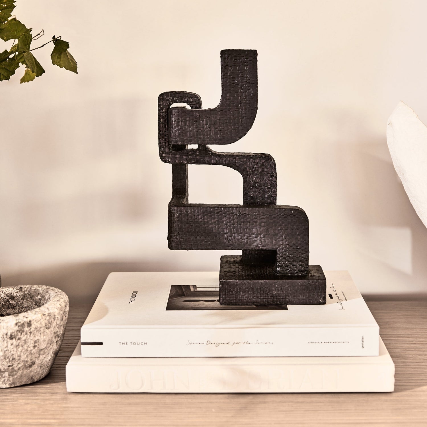 abstract black sculpture on white books, against a white wall - Number 2