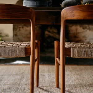 Wooden chairs with woven seats around a wooden table in a rustic setting. - Number 3