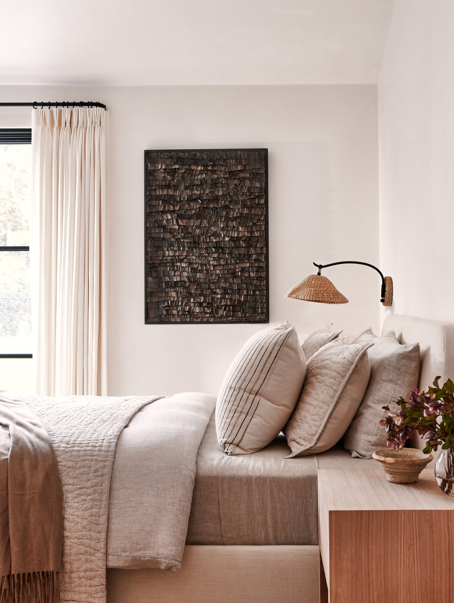 Neatly made bed with pillows and a lamp in a bedroom setting.- Number 2