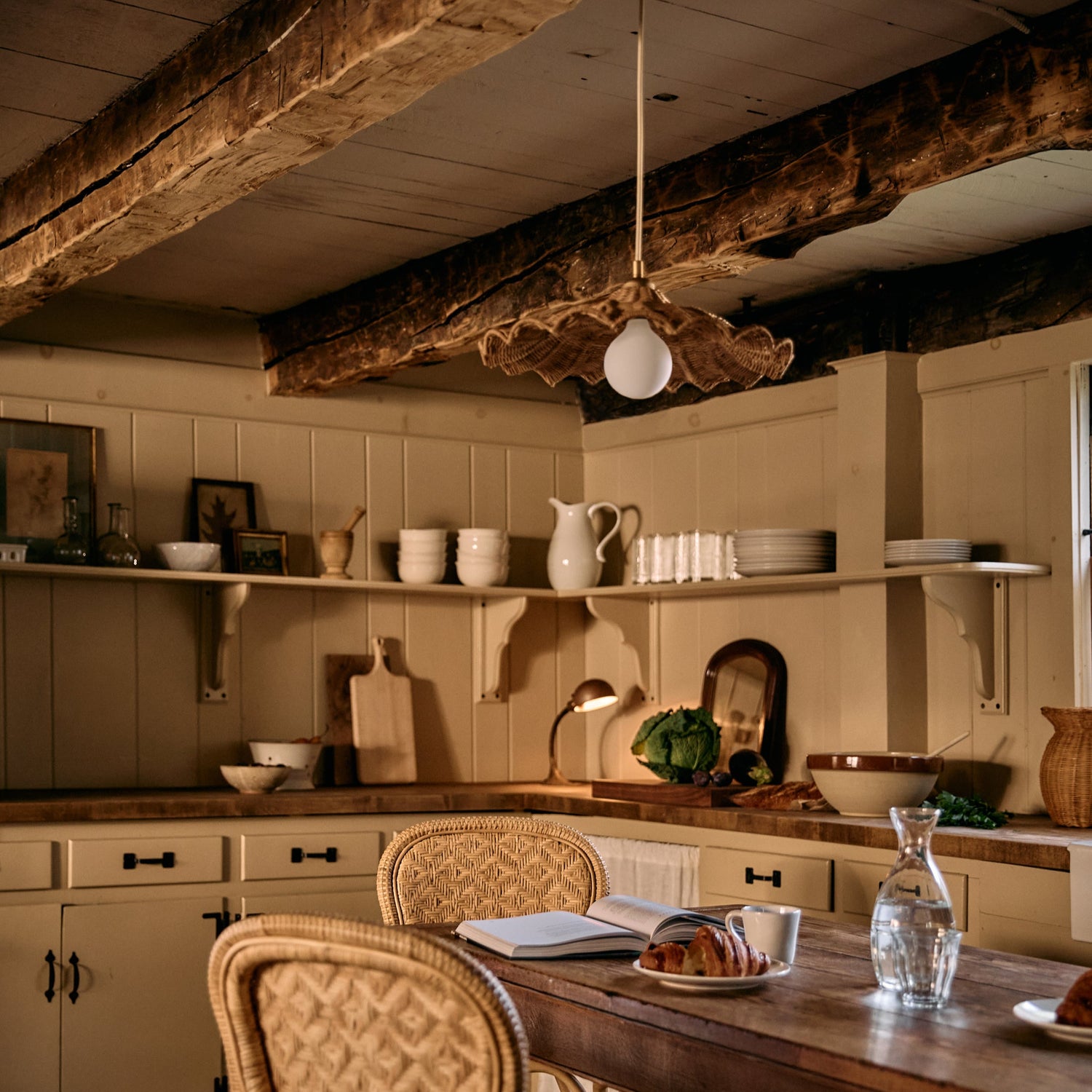 Cozy kitchen with wooden table, chairs, and shelves with various items.- Number 4