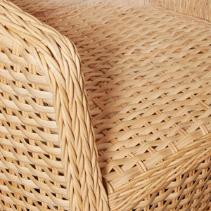 Close-up of a woven rattan chair or basket seat showing the natural light tan woven texture and curved armrest edge. - Number 8