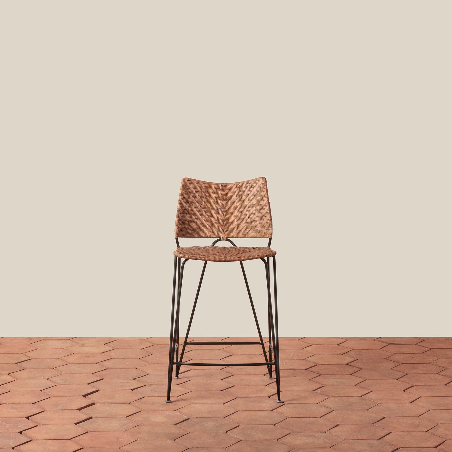 Wooden bar stool with woven seat on a wooden floor and beige wall background- Number 3