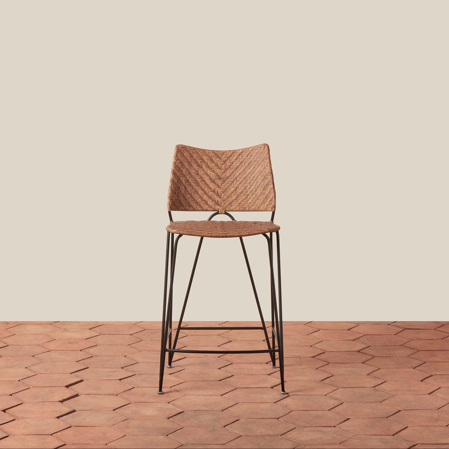Wooden bar stool with woven seat on a wooden floor and beige wall background- Number 3