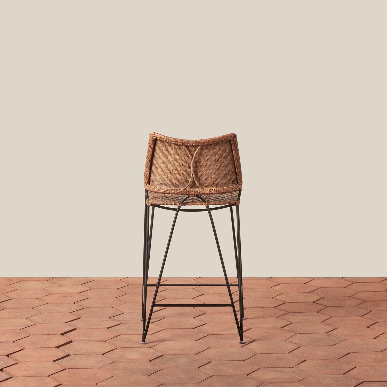 Bar stool with woven seat and metal legs on a wooden floor and beige wall background- Number 4