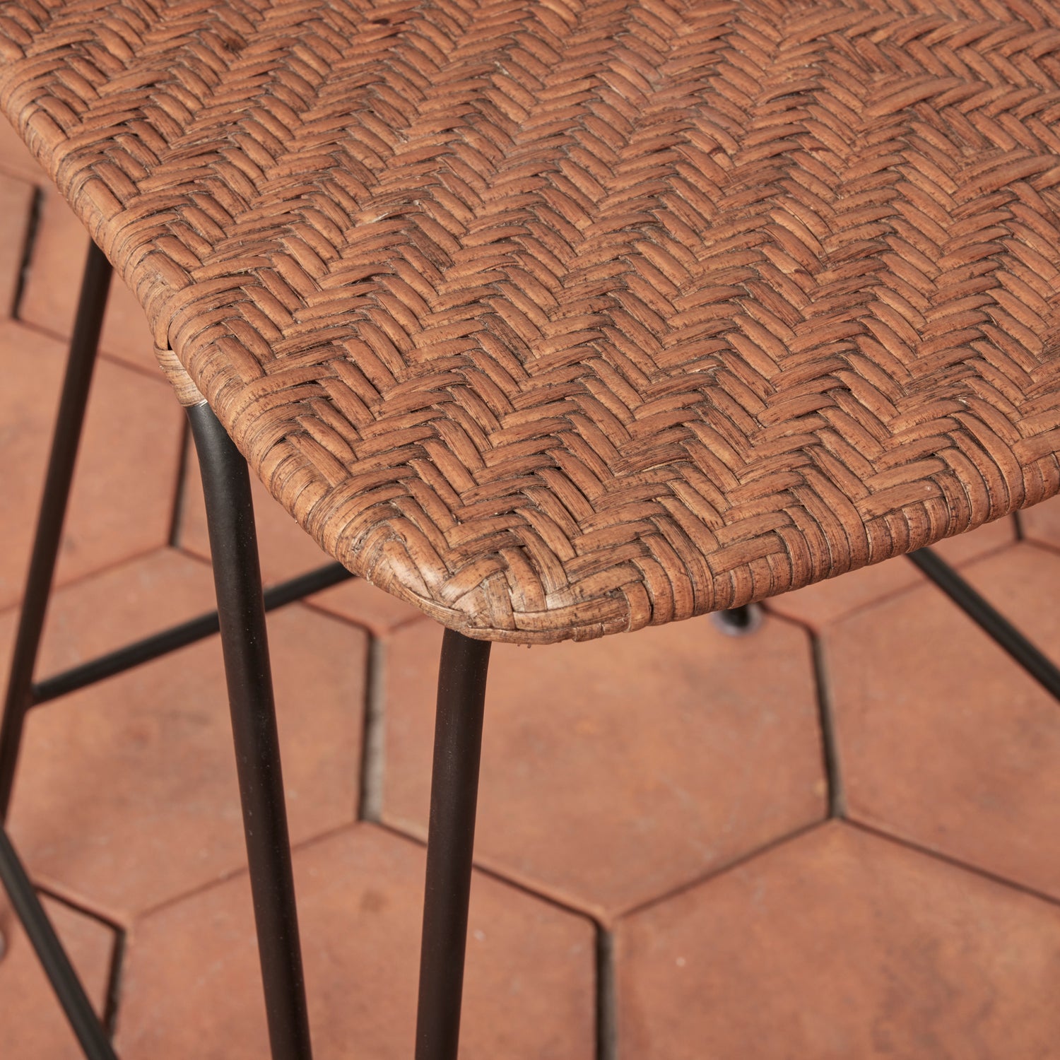 Close-up of a wicker chair seat on a brick pavement- Number 6