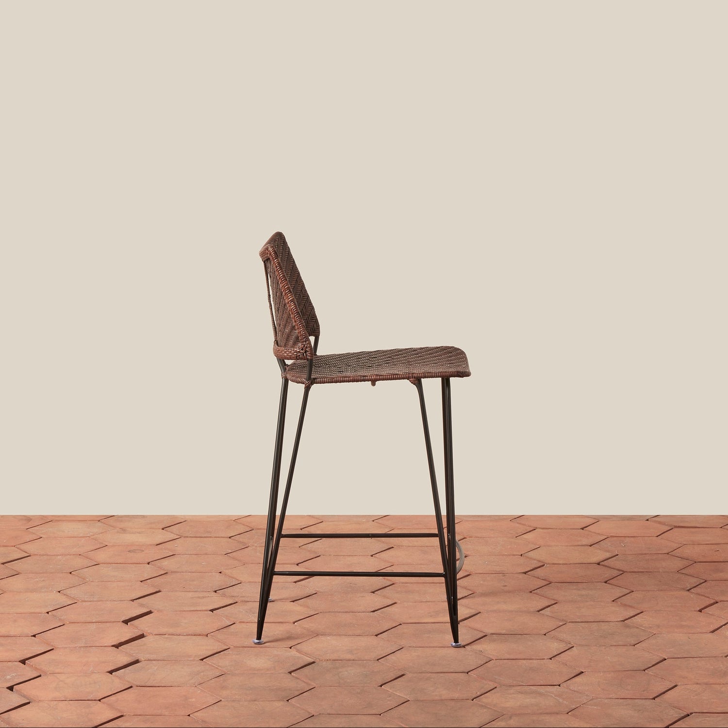 Bar stool with woven seat and metal legs on a wooden floor with beige wall background- Number 8