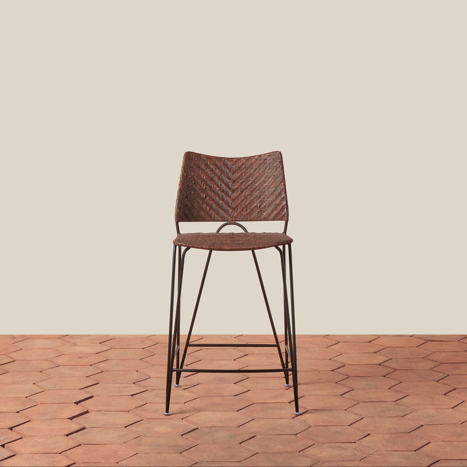 Brown woven bar stool on a wooden floor with a beige wall background- Number 9