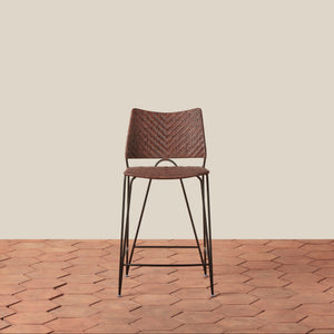 Brown woven bar stool on a wooden floor with a beige wall background - Number 9