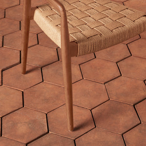 Brown hexagonal tiles on a patio with a woven chair. - Number 6