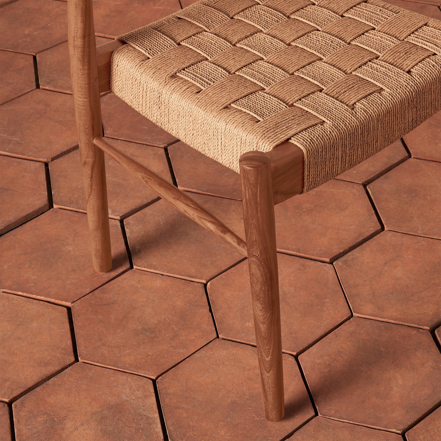 Wooden stool with woven seat on a hexagonal tile floor- Number 8