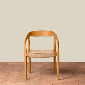 Wooden chair with woven seat on a wooden floor and beige wall background - Number 17