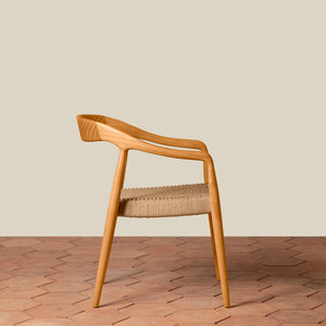 Wooden chair with woven seat on a wooden floor and beige wall background - Number 18