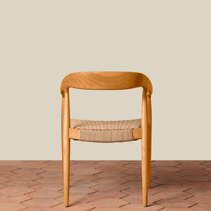 Wooden chair with woven seat on a wooden floor and beige wall background - Number 19