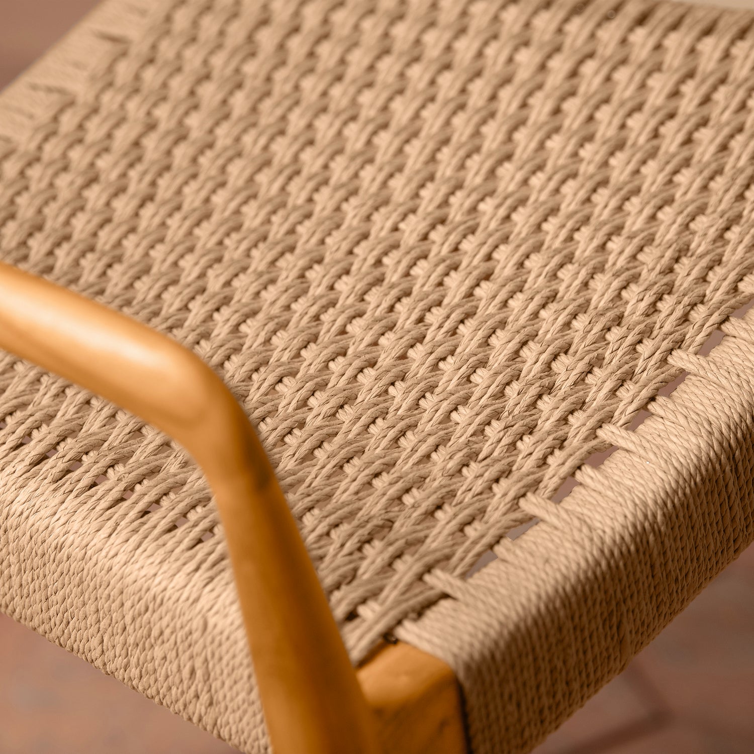 Close-up of a woven chair seat with a wooden armrest.- Number 22