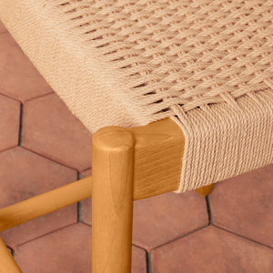 Close-up of a woven chair seat with wooden armrest on a tiled floor background - Number 7