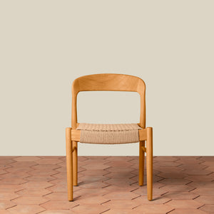 Wooden chair with woven seat on a wooden floor and beige wall background - Number 15