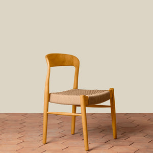 Wooden chair with woven seat on a wooden floor and beige wall background - Number 14