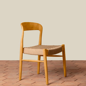 Wooden chair with woven seat on a wooden floor and beige wall background - Number 14