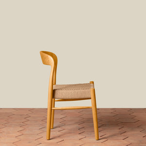 Wooden chair with woven seat on a wooden floor and beige wall background - Number 16