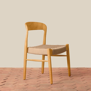 Wooden chair with woven seat on a wooden floor and beige wall background - Number 13