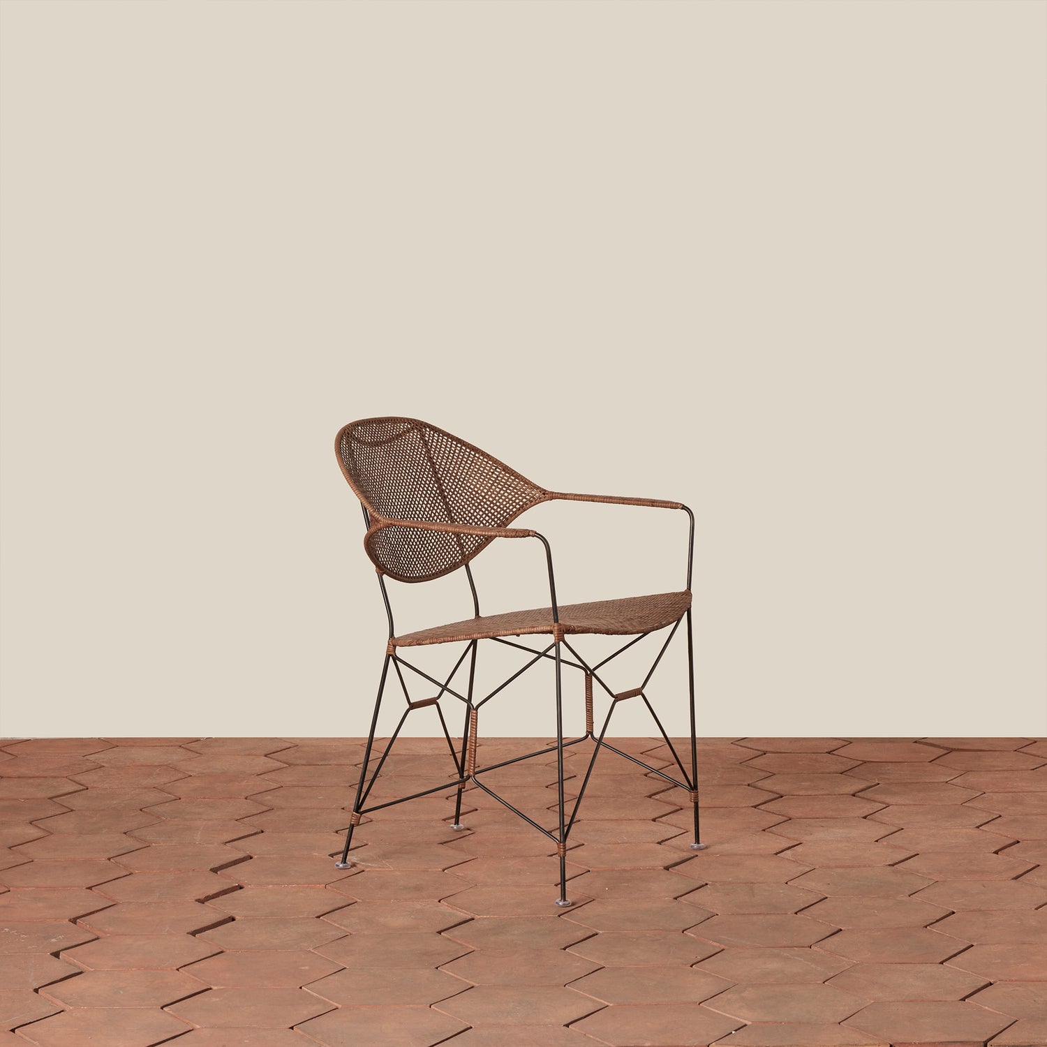 brown rattan and iron chair with pointed legs on tile floor against white background- Number 1