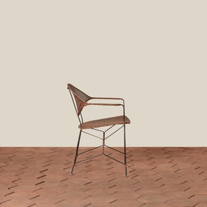 brown rattan and iron chair with pointed legs on tile floor against white background - Number 2