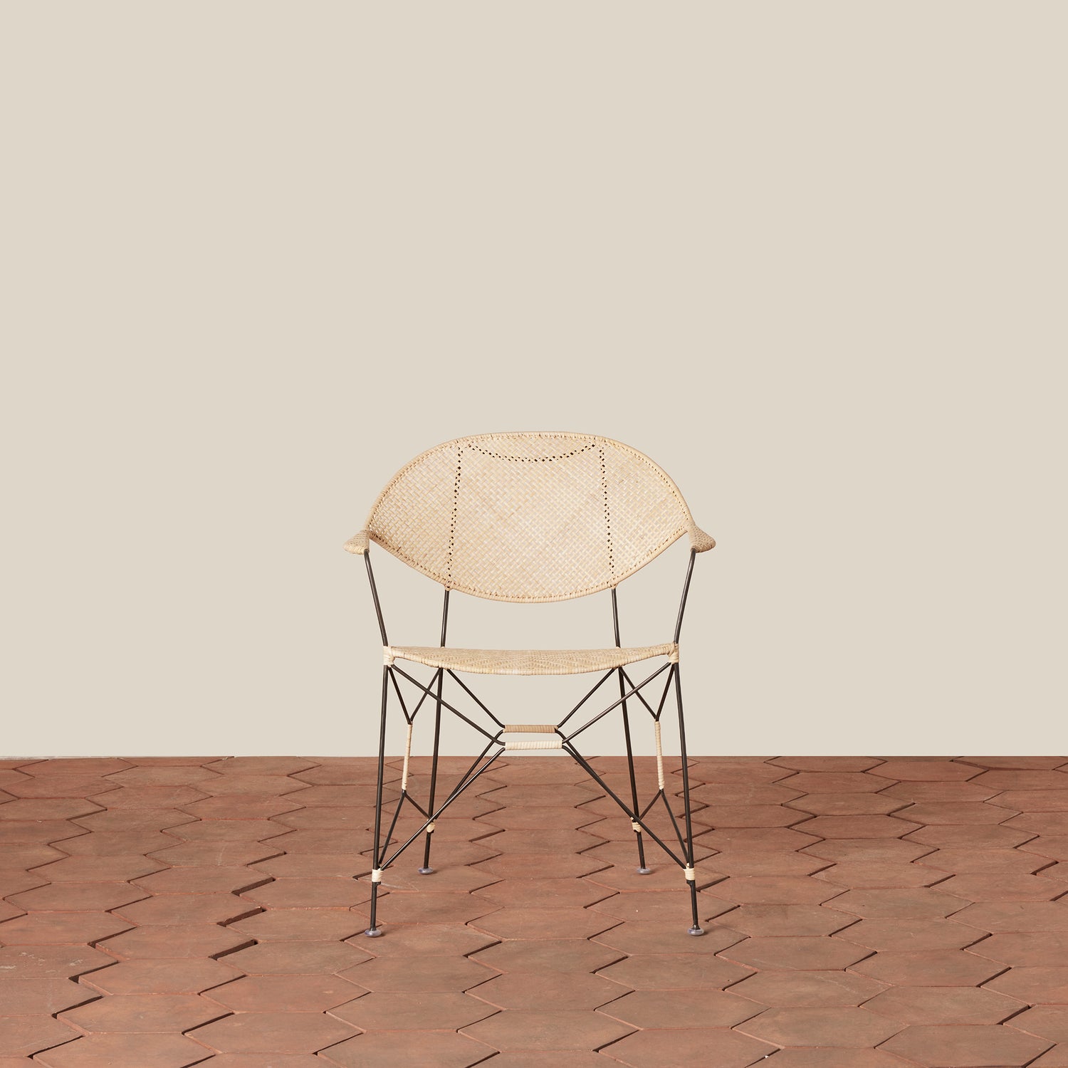 white and black rattan and iron chair with pointed legs on tiled floor against white background- Number 11