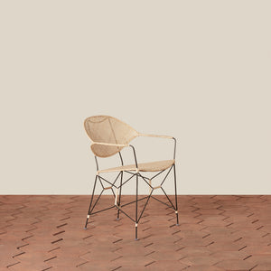 white and black rattan and iron chair with pointed legs on tiled floor against white background - Number 9