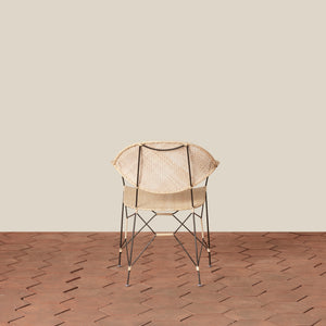 white and black rattan and iron chair with pointed legs on tiled floor against white background - Number 10