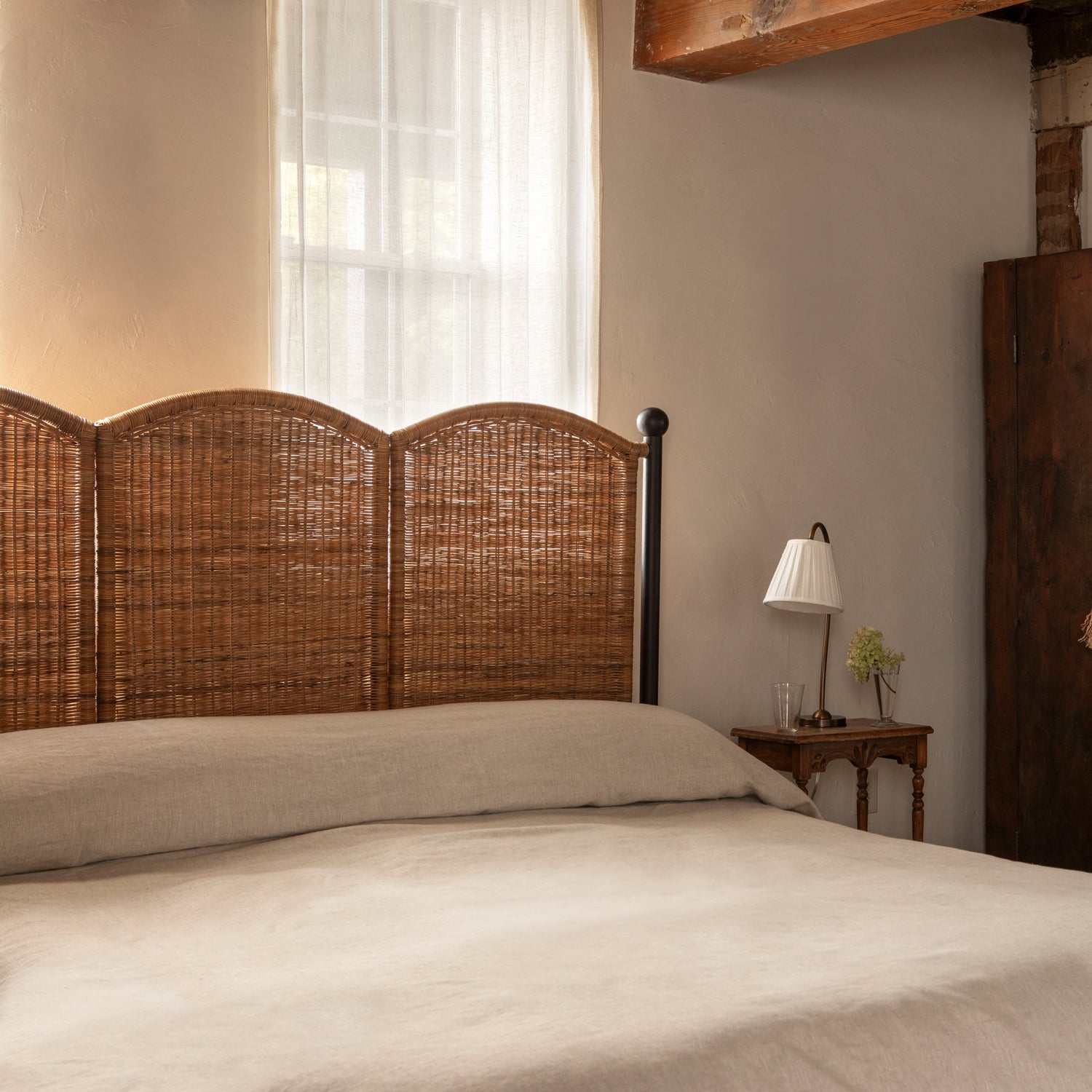 Bedroom with wooden headboard, lamp, and wardrobe.- Number 3