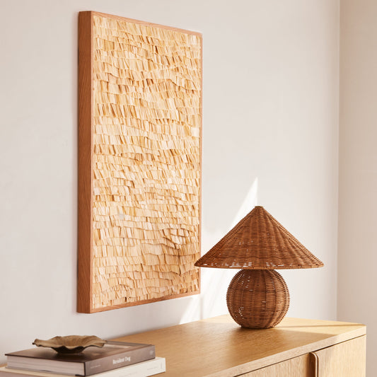 Wooden sideboard with a textured wall art piece and a wicker lamp. - Image 2