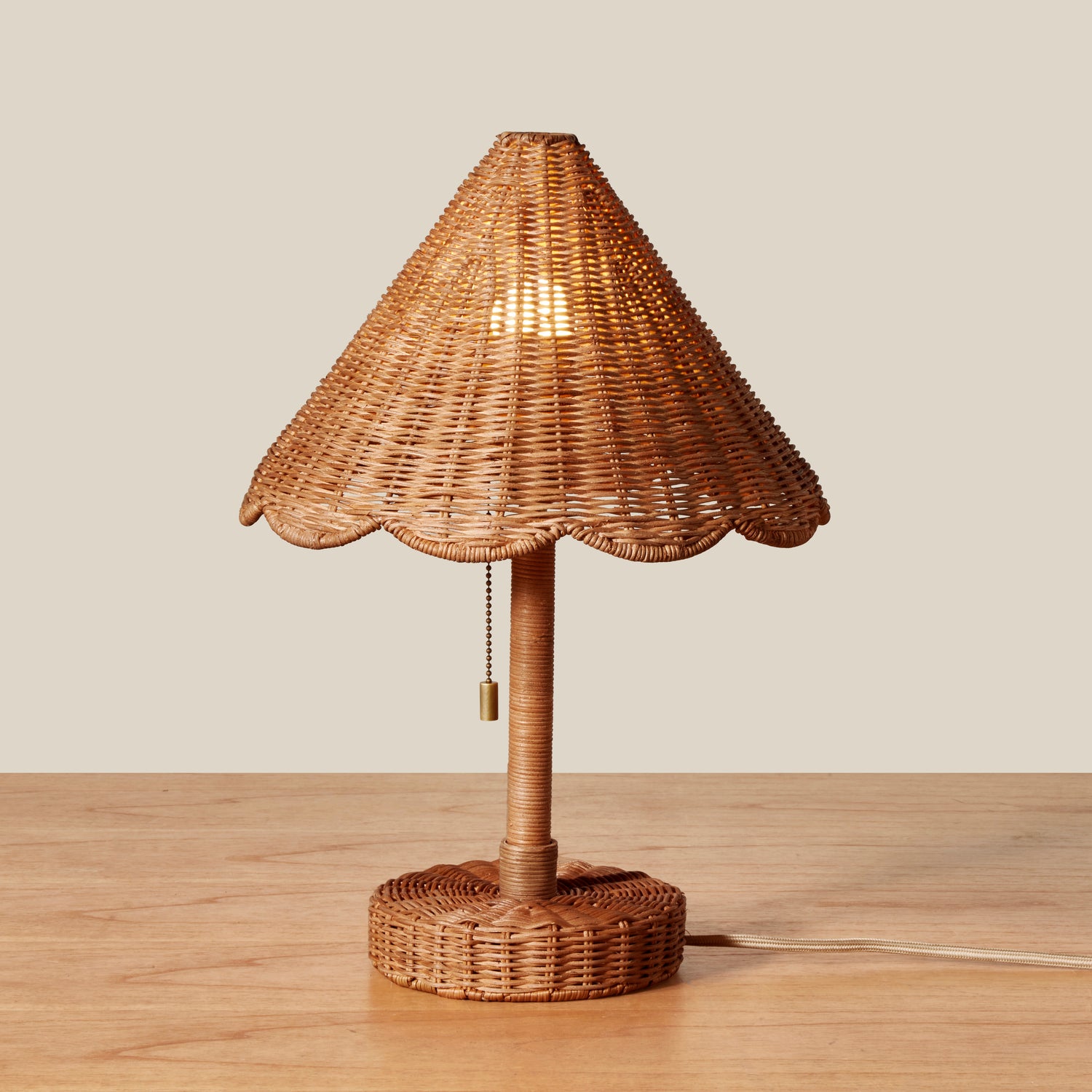 Wicker table lamp with a textured shade on a wooden surface.- Number 3