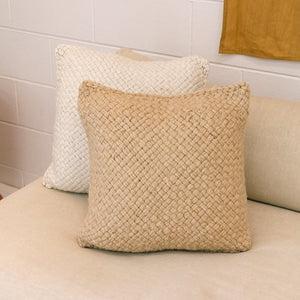 Woven beige pillow on a white cushion with a white tiled wall background - Number 2