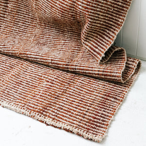 Textured brown and beige rug on a white floor - Number 2