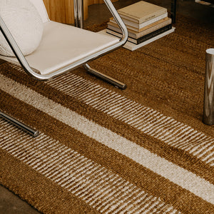 Modern chair with a striped rug and books in a room with wooden walls. - Number 2